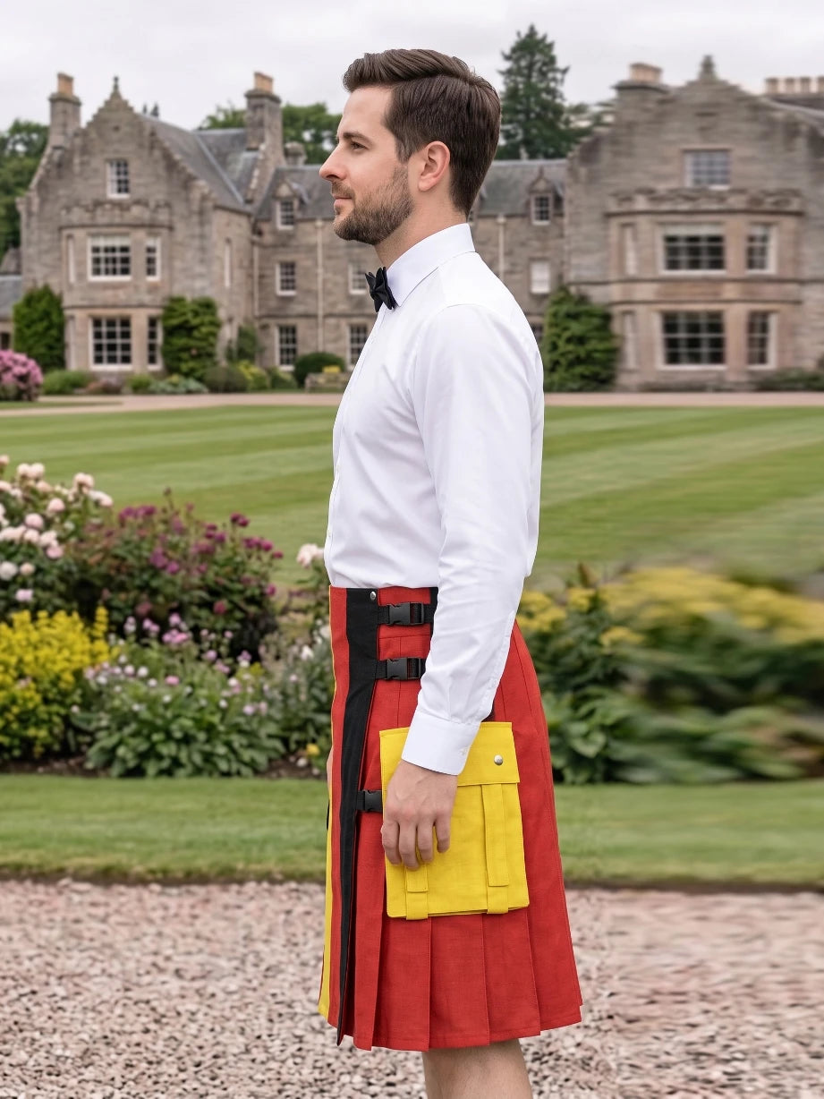 A man wearing a white dress shirt, black bow tie, and a red kilt with black and yellow accents, standing in a garden with a large stone mansion in the background.