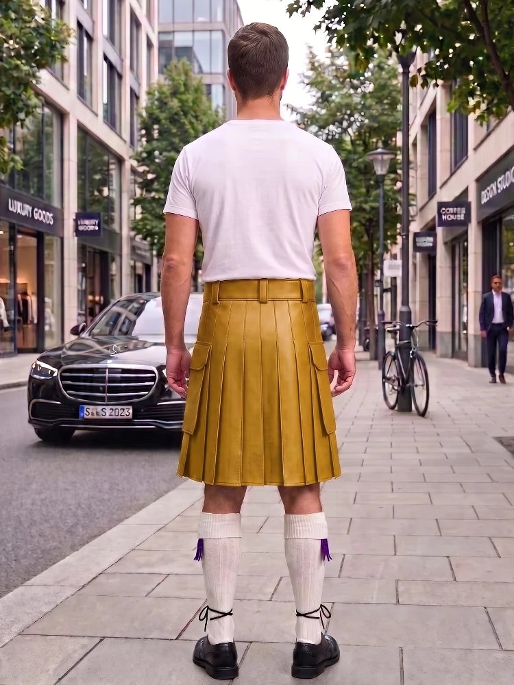 A man viewed from behind wearing a mustard yellow leather kilt, white t-shirt, white knee-high socks, and black shoes, standing on a city sidewalk.