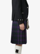 Person wearing a black jacket and plaid kilt on a white background