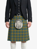 Person wearing a green and yellow plaid kilt with a dark jacket on a white background