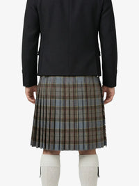 Person wearing a black jacket and plaid kilt on a white background