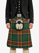 Person wearing a traditional Scottish kilt with a tartan pattern on a white background