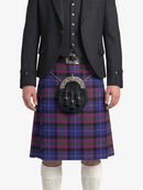 Person wearing a dark gray jacket and a purple plaid kilt on a white background