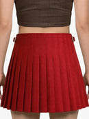 Red pleated skirt worn by a person on a plain background
