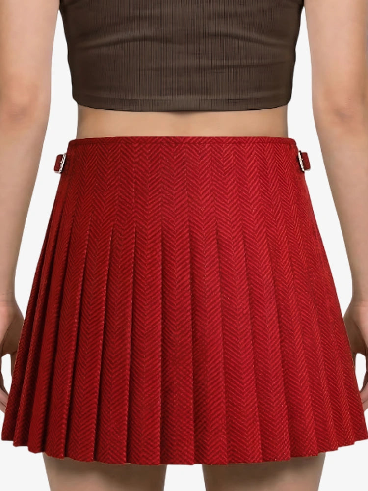 Red pleated skirt worn by a person on a plain background