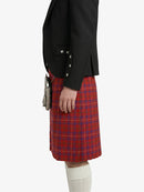 Person wearing a black blazer and red plaid kilt on a white background