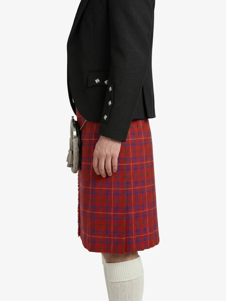 Person wearing a black blazer and red plaid kilt on a white background