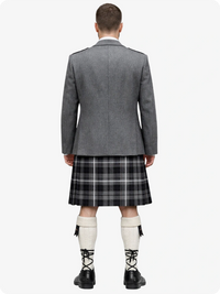 Person wearing a gray blazer and plaid kilt on a white background