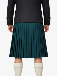 Person wearing a dark coat and green pleated kilt on a white background