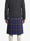 Person wearing a gray jacket and blue plaid kilt on a white background