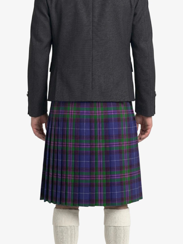 Person wearing a gray jacket and blue plaid kilt on a white background