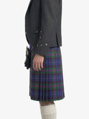 Person wearing a dark gray jacket and a blue plaid kilt on a white background