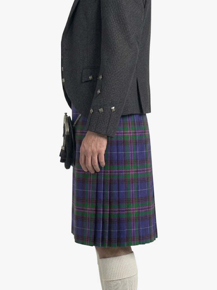 Person wearing a dark gray jacket and a blue plaid kilt on a white background