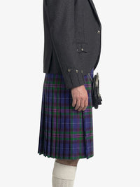Person wearing a dark gray jacket and a blue plaid kilt on a white background