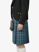 Person wearing a black jacket and blue plaid kilt on a white background