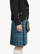 Person wearing a black jacket and blue plaid kilt on a white background