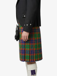 Person wearing a black jacket and colorful plaid kilt on a white background