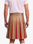 A man wearing a tan pleated leather kilt with red lining and silver-tone decorative hardware, paired with a light pink t-shirt, shown from the back against a light gray background.