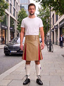 A man stands on a city sidewalk wearing a beige leather kilt with red side panels, a white t-shirt, white knee-high socks, and black shoes. Buildings, trees, and a parked black car are visible in the background.