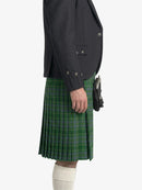 Person wearing a dark jacket and green plaid kilt on a white background