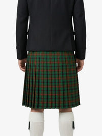Person wearing a black jacket and green plaid kilt on a white background