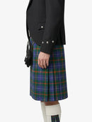 Person wearing a black jacket and plaid kilt on a white background