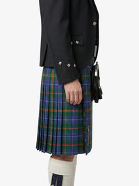 Person wearing a black jacket and plaid kilt on a white background