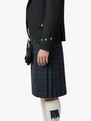 Person wearing a black jacket and plaid kilt on a white background
