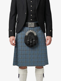 Person wearing a traditional Scottish kilt with a jacket on a white background