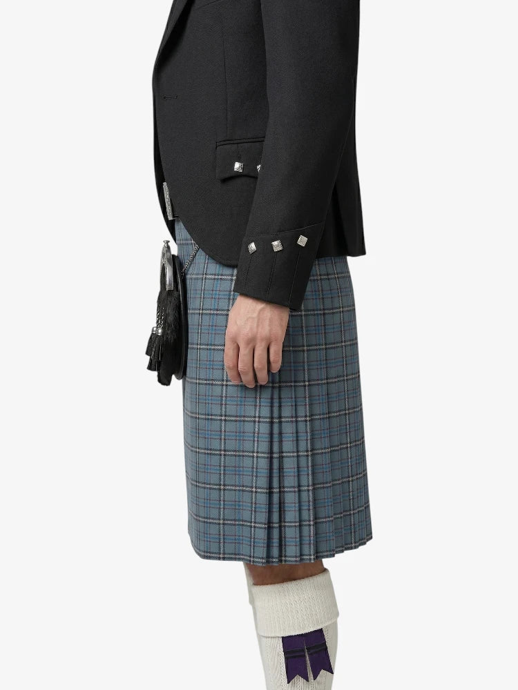 Person wearing a black jacket and blue plaid kilt on a white background