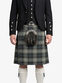 Person wearing a traditional Scottish kilt with a jacket and white socks on a white background