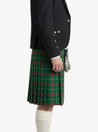 Person wearing a black jacket and green plaid kilt on a white background