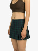 Person wearing a green plaid skirt and brown top on a white background